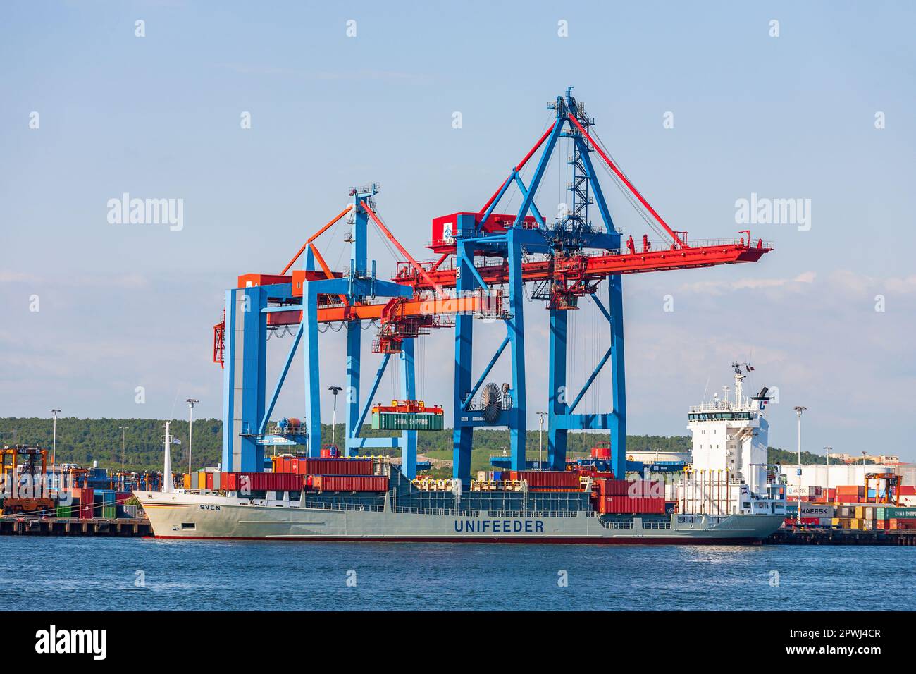 Container terminal gantry crane lifting cargo container in sea port hi ...