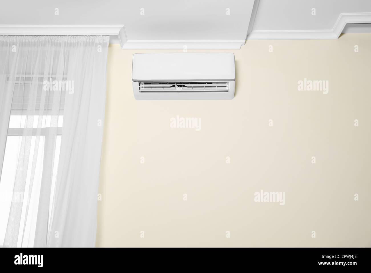 Modern air conditioner on white wall indoors Stock Photo - Alamy