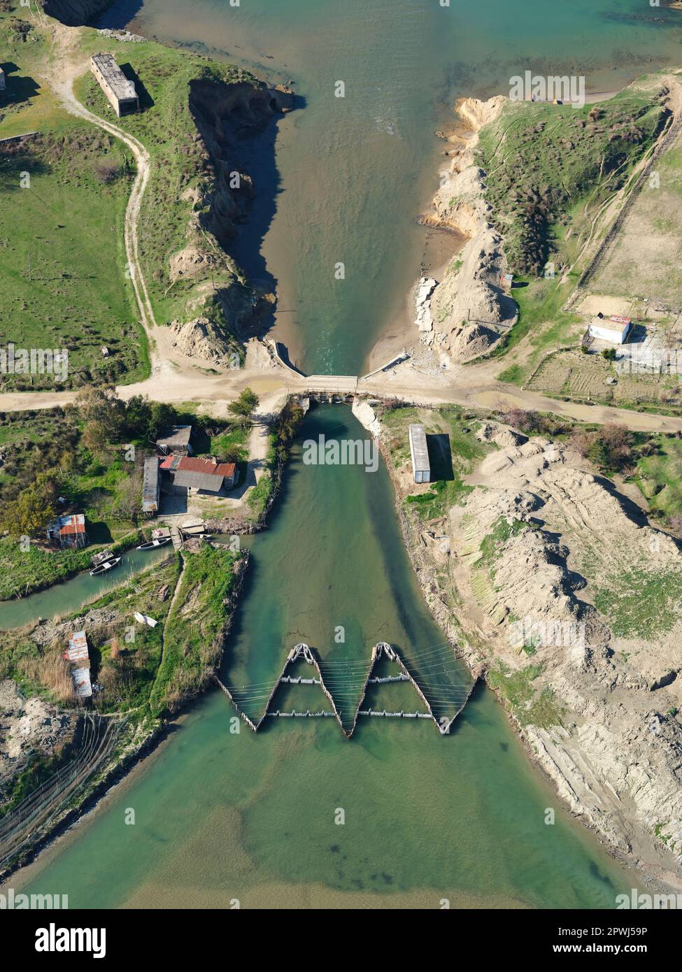 AERIAL VIEW. Fishing weir on a channel between the Adriatic Sea and the Narta Lagoon. Zvërnec, Vlorë County, Albania. Stock Photo