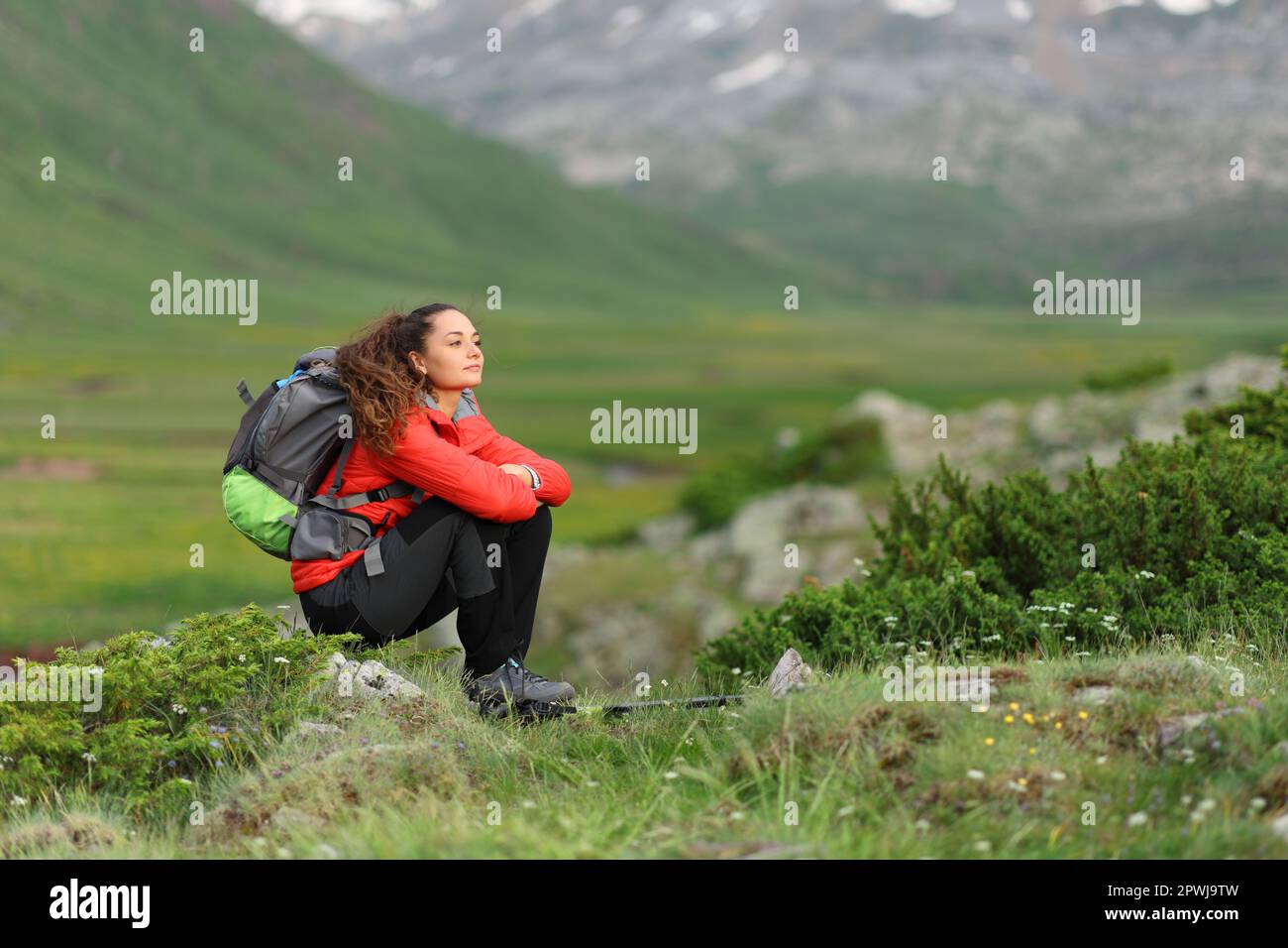 Hiker sitting in a beautiful valley looking away Stock Photo