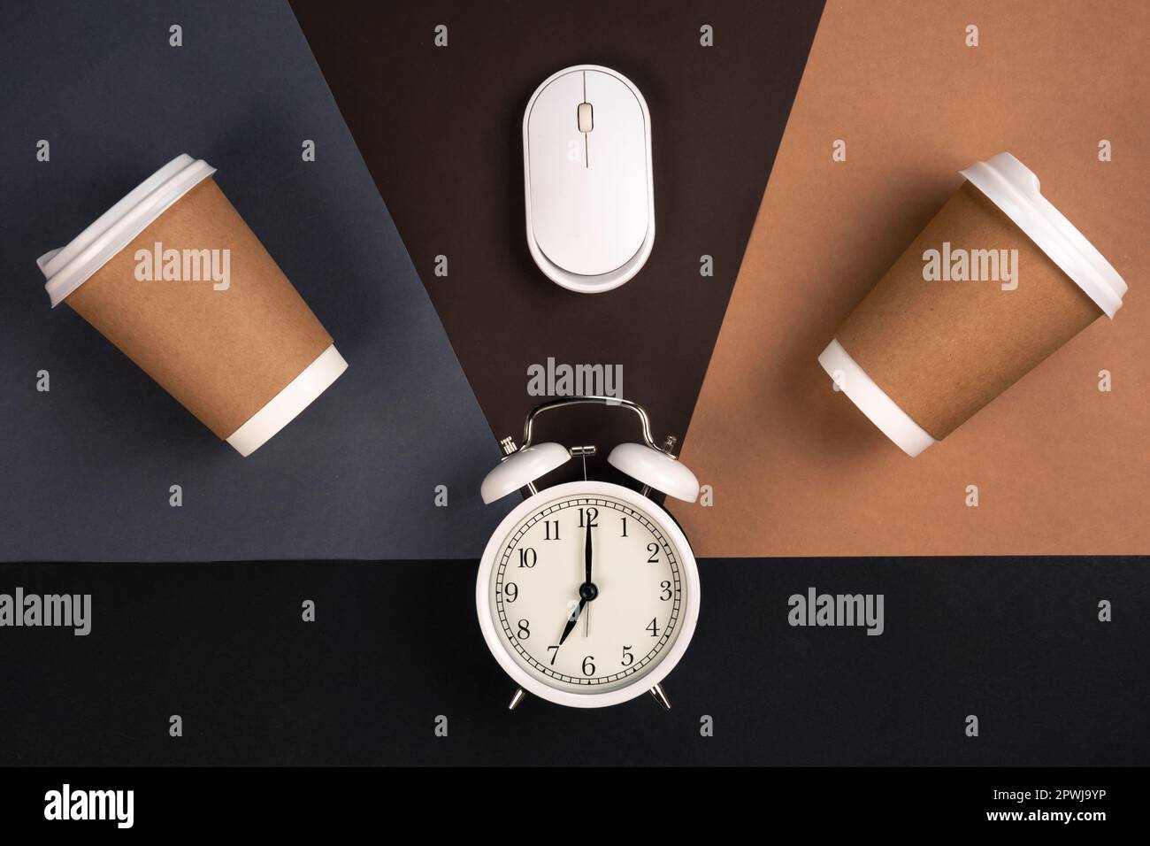 Alarm clock, paper cups and computer mouse on a paper background, top ...