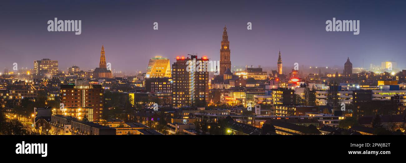 An evening photo of the skyline of Groningen in a wide 3:1 panorama image. The view is towards the city center with the A-Kerk, the Martinitoren, the Stock Photo