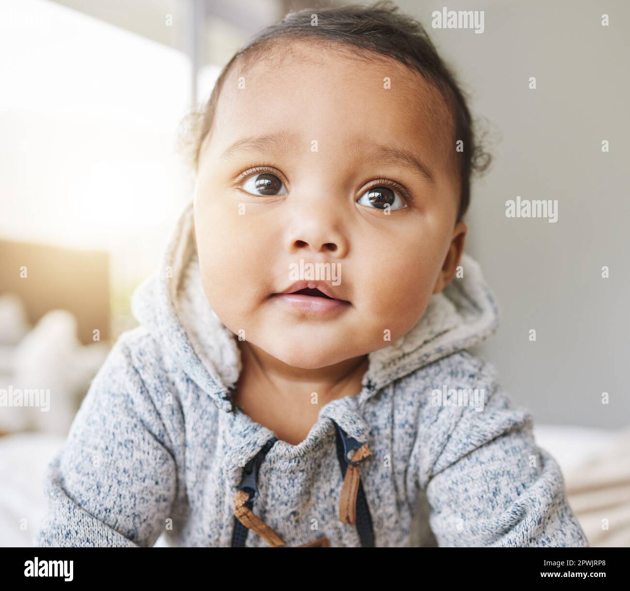 A thief of hearts. an adorable baby boy playing on the bed at home
