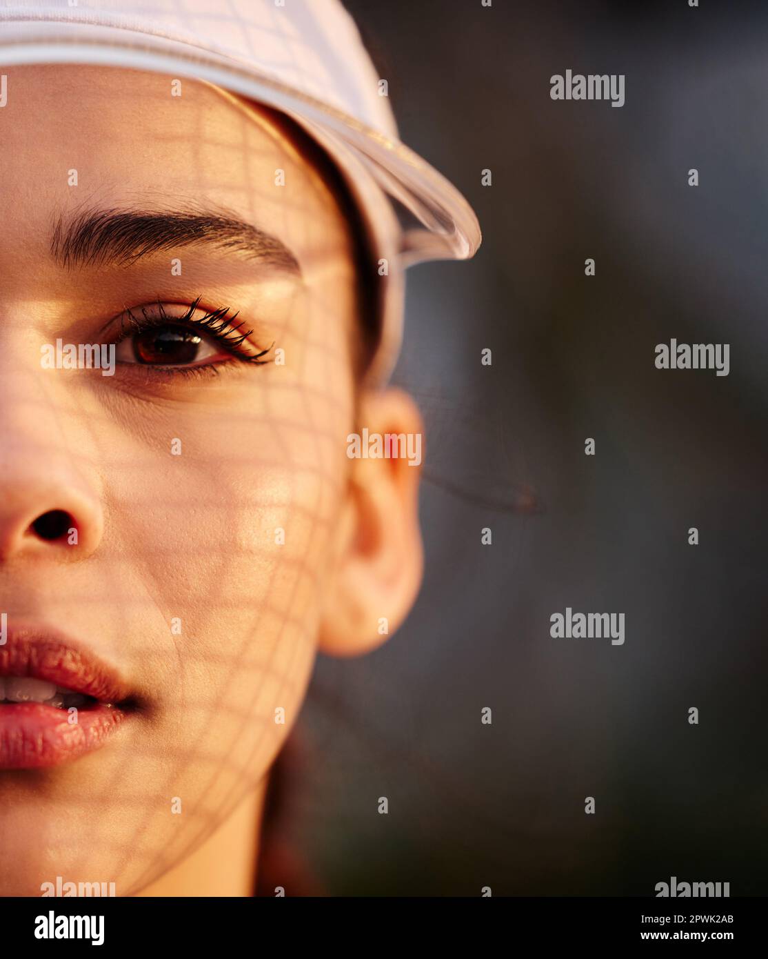 I look my opponents in the eye then I wish them luck. Closeup shot of a tennis player wearing a white visor Stock Photo