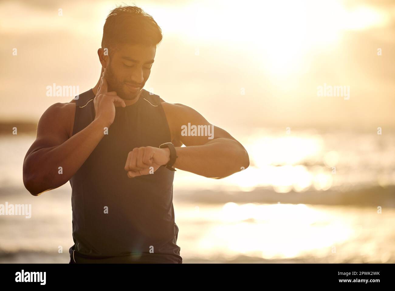 Body built strong like a machine. a sporty young man checking his pulse while exercising outdoors Stock Photo