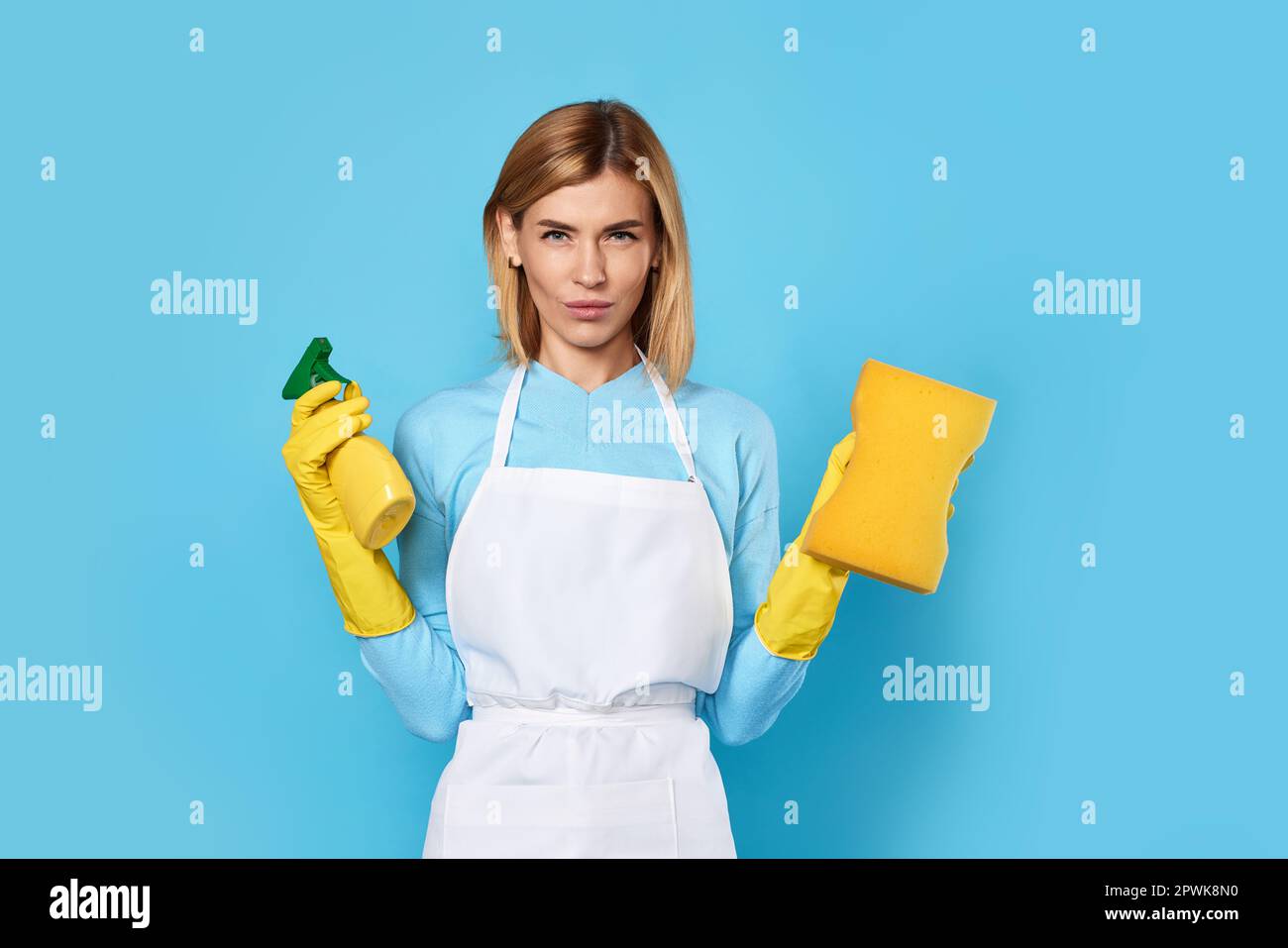confident caucasian blonde woman in yellow rubber gloves and cleaner ...