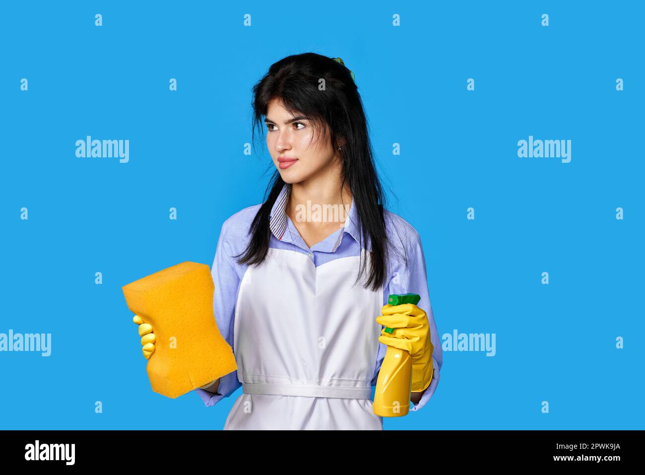 upset caucasian woman in yellow rubber gloves and cleaner apron with ...