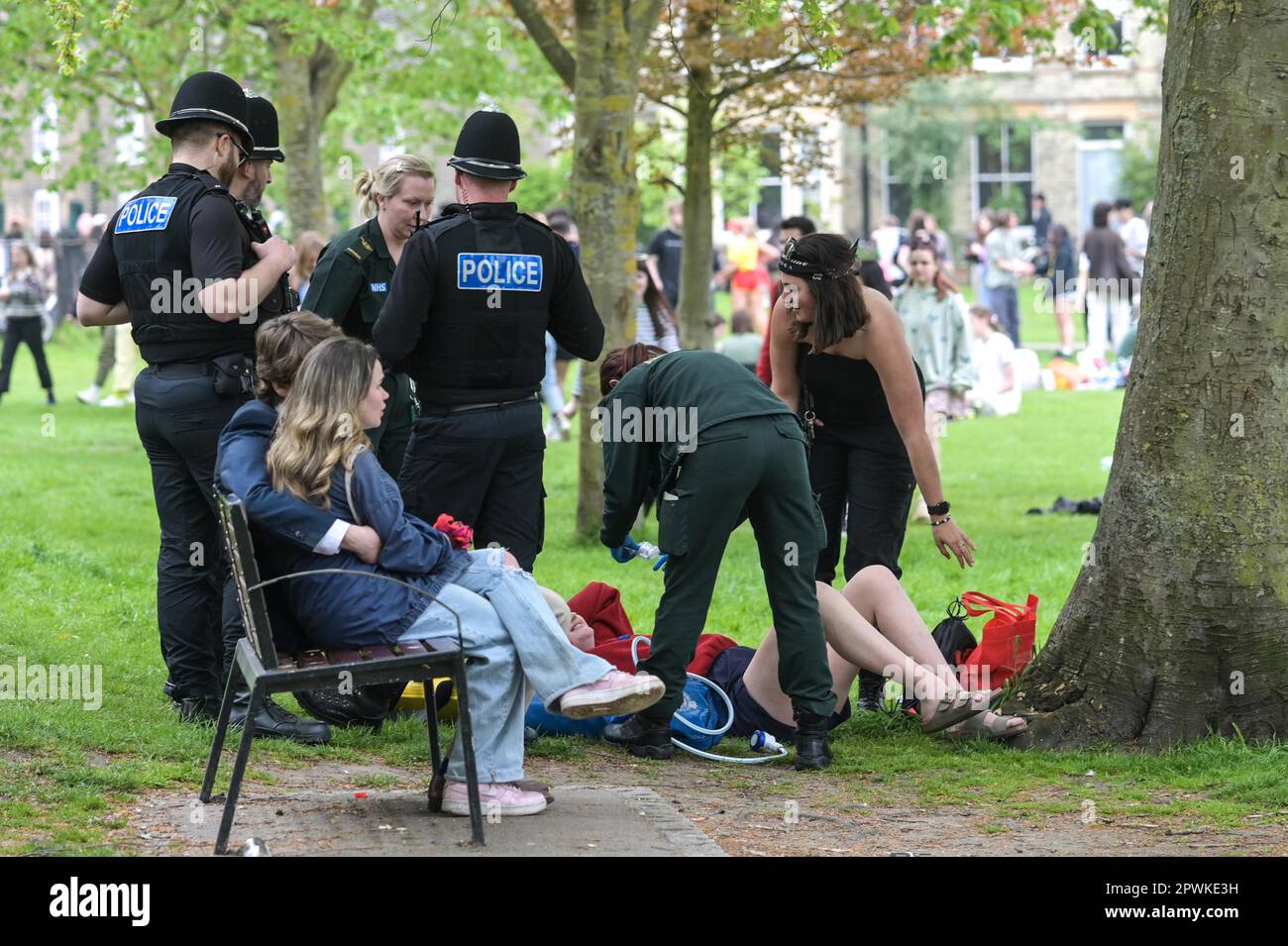 Jesus Green, Cambridge, 30th April 2023 A student was attended to by paramedics and police officers after falling from a tree as hordes of Cambridge University students flocked to a park on Sunday afternoon in the Bank Holiday sunshine for the annual 'Caesarian Sunday' drinking party. Undergraduates from the prestigious institution frolicked through the afternoon in fancy dress taking part in drinking games on Jesus Green. The tradition, also known as ‘C-Sunday' attracts thousands of students just before they take part in exams. Police were present to keep the academics in check. Credit: Ben F Stock Photo
