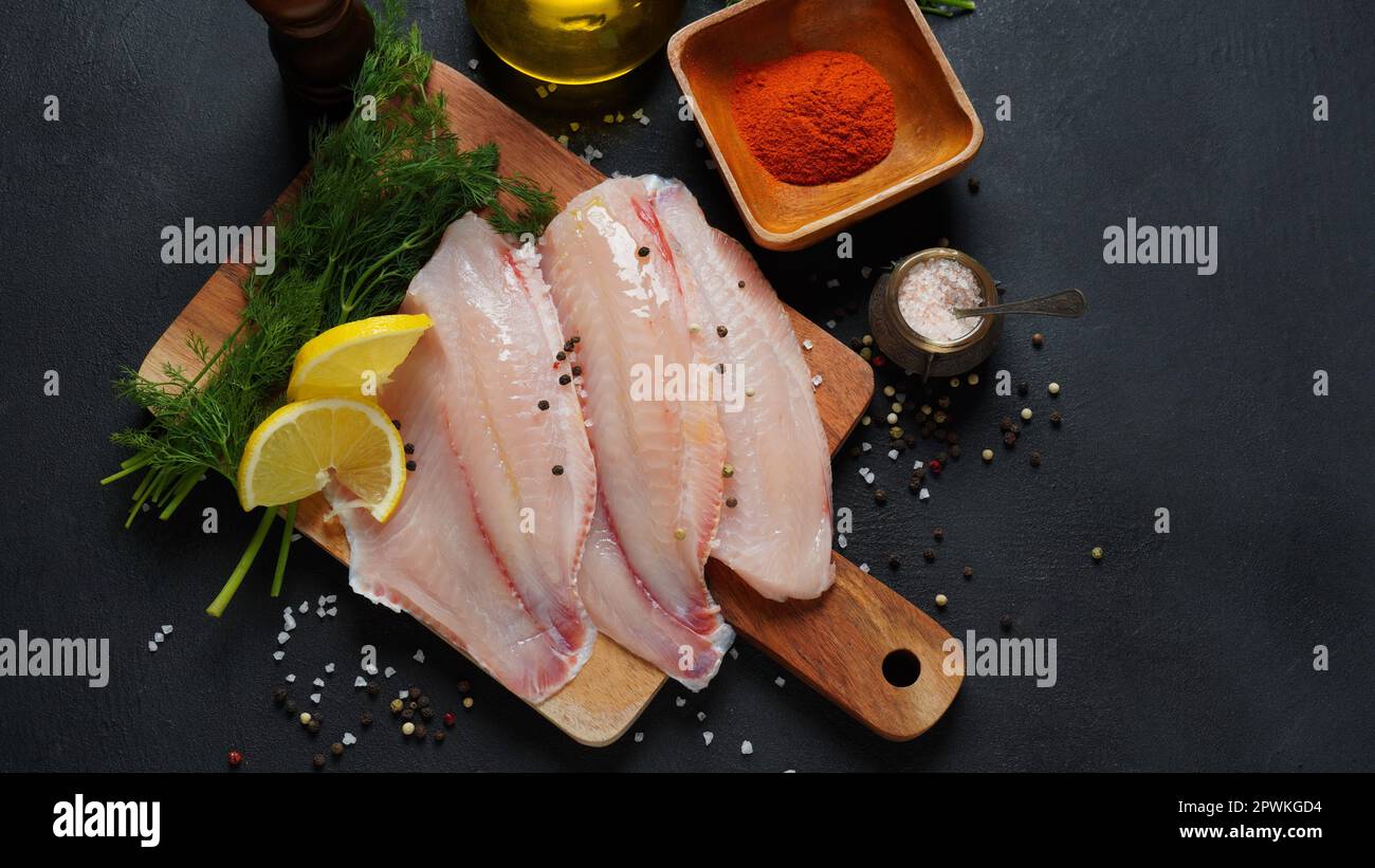 Fresh red tilapia fish fillet sliced for steak or salad with herbs