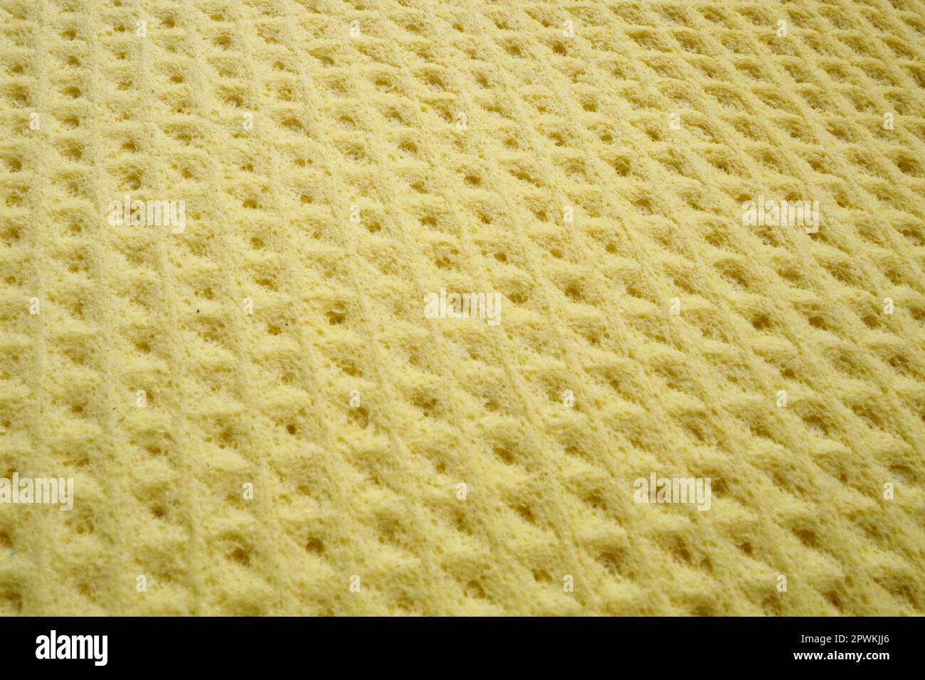 Sponge fibers sponge texture pattern surface close-up yellow background. Stock Photo