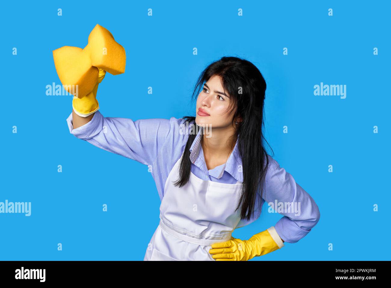 diligent woman in rubber gloves and cleaner apron cleaning with yellow ...