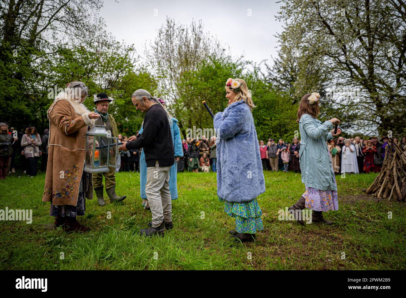 A candle flame is used to light the Beltane bonfire at Chalice Well ...