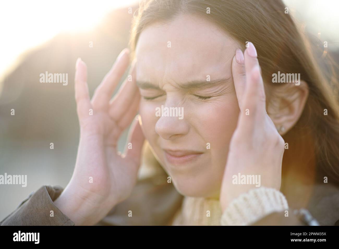 Close up of a woman suffering head ache outdoors and complaining Stock Photo