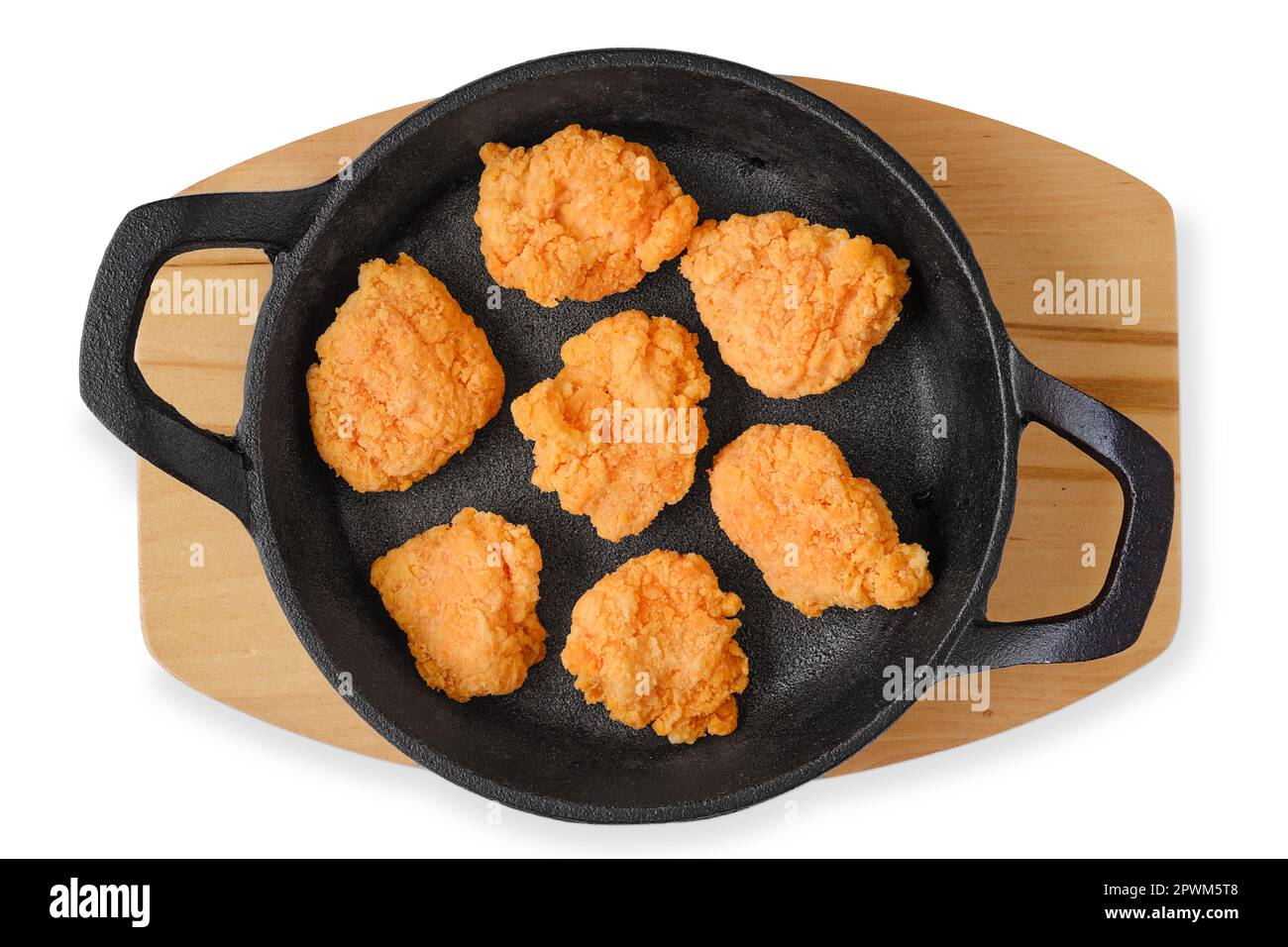 Top view of semifinished frozen chicken drumsticks in cast iron skillet
