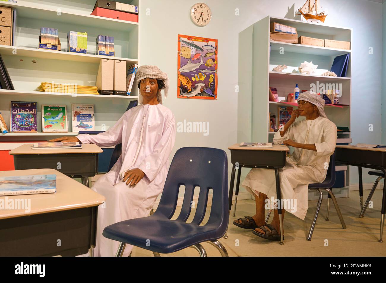 Two boys, sitting at desks in a school classroom, studying and learning, getting an education. A diorama depicting a scene from UAE's past, at the Abu Stock Photo