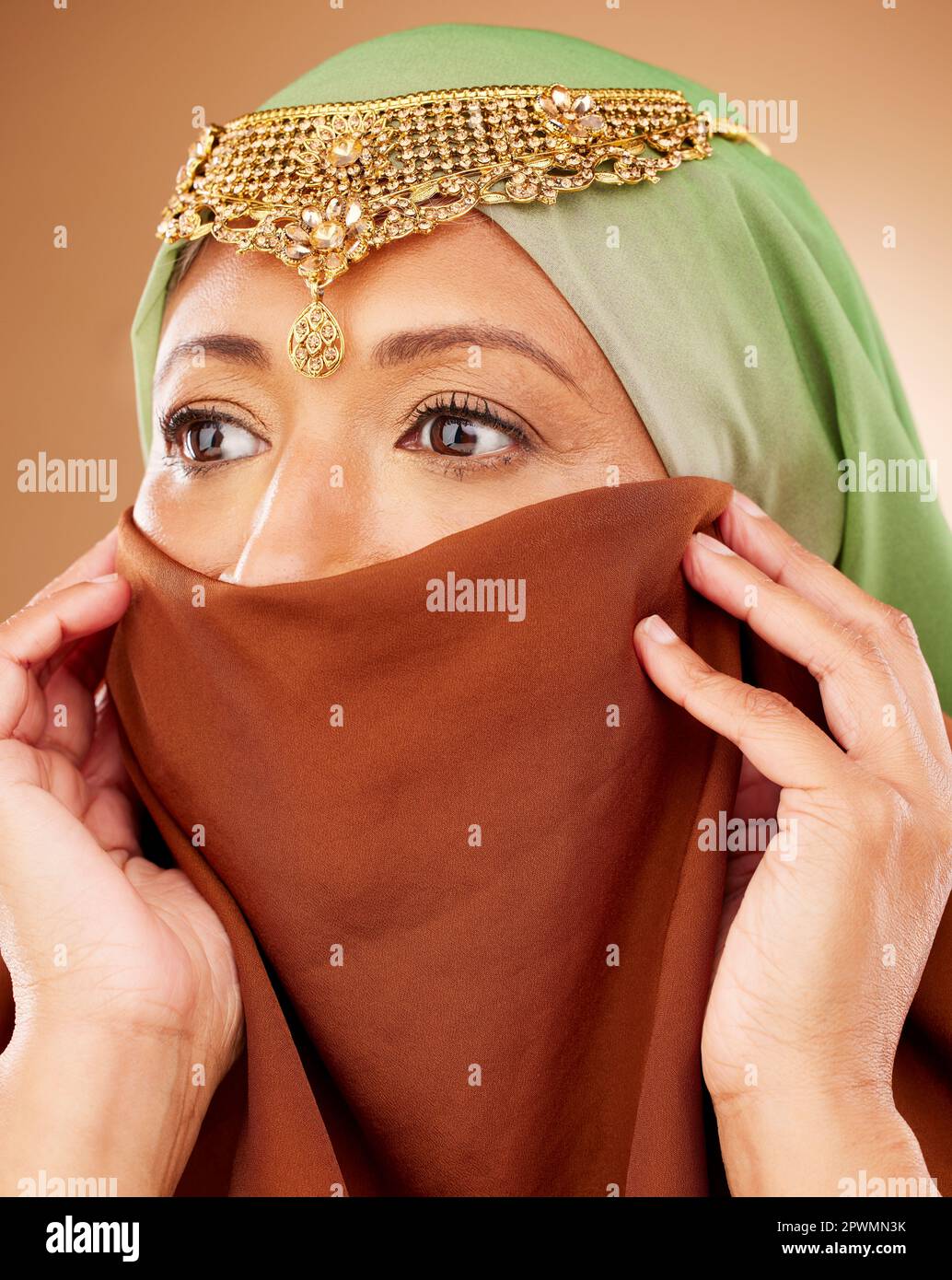 Muslim, skincare and woman with hijab in studio for beauty, wellness and cosmetic treatment on brown background. Islam, girl and model in face scarf r Stock Photo