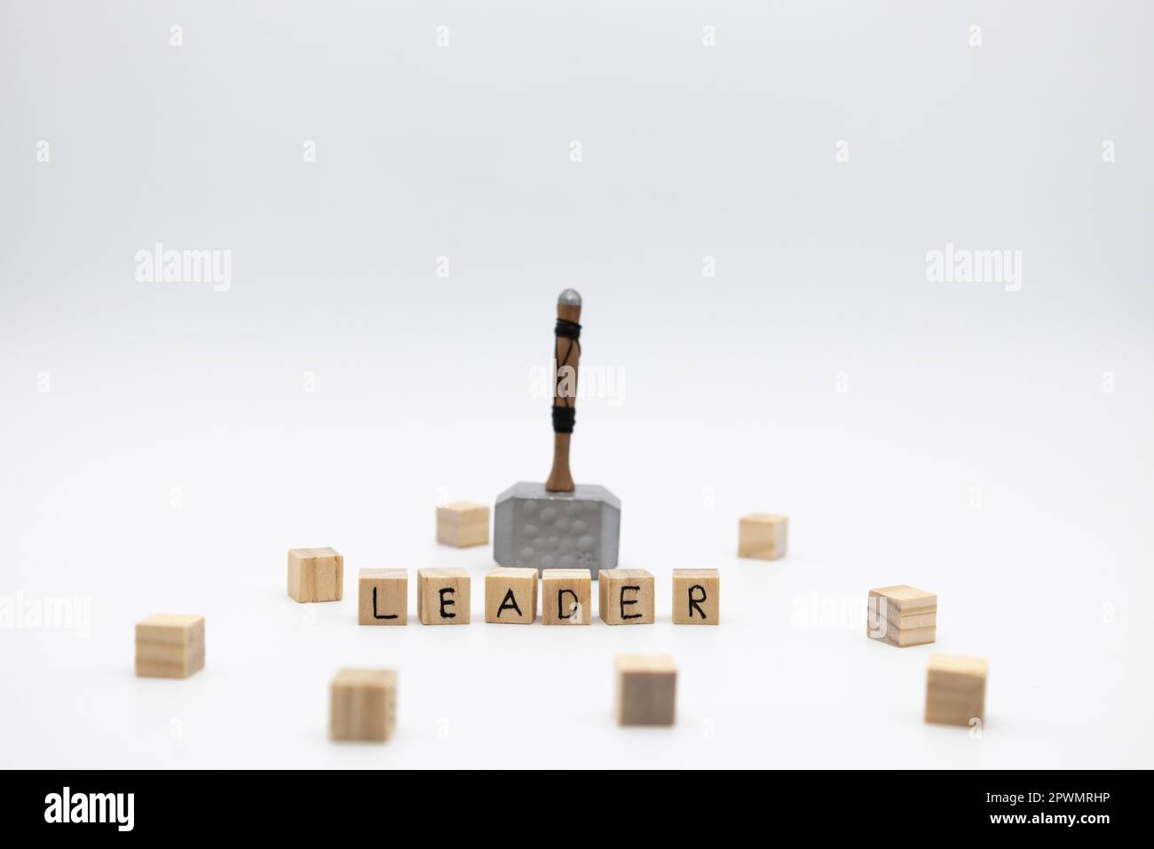 The hammer is standing on the wooden cubes with the word LEADER against white background Stock Photo