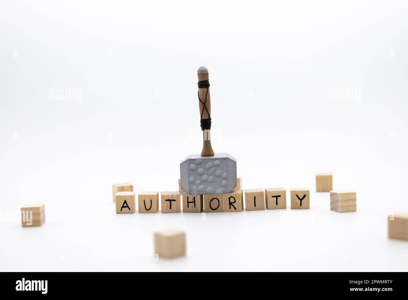 The hammer is standing on the wooden cubes with the word AUTHORITY against white background Stock Photo