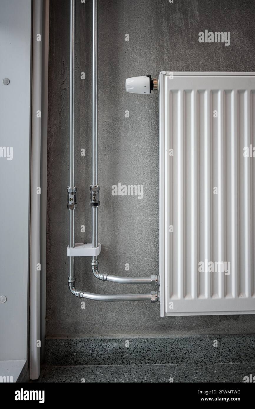 Heating pipes and radiator on a concrete wall Stock Photo Alamy