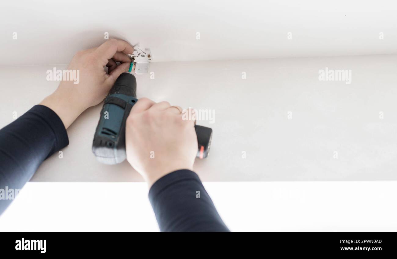 Handyman using a cordless screwdriver. Qualified worker services, home repair and renovation. Stock Photo