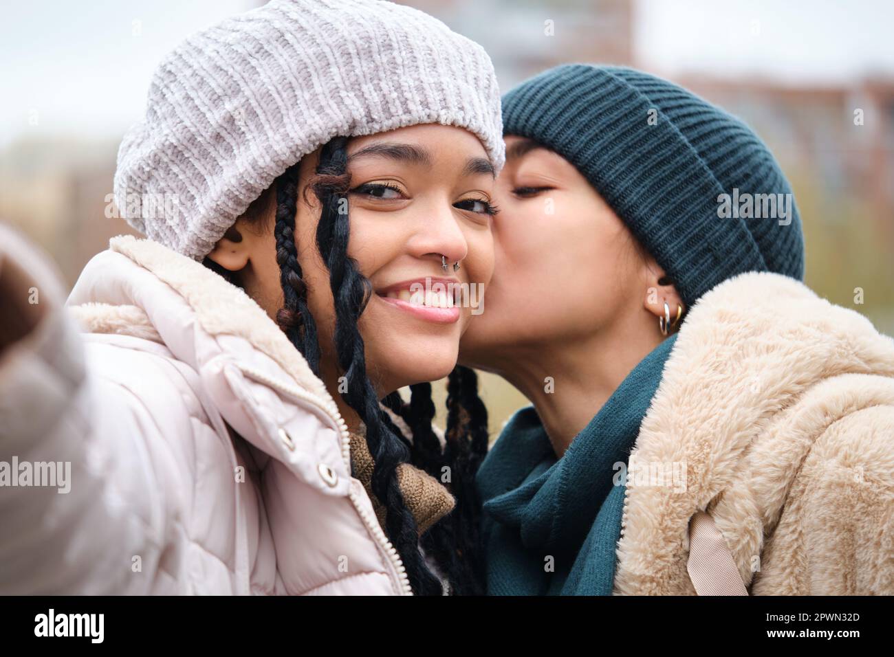 Happy dominican lesbian couple taking a selfie while kissing on the cheek  Stock Photo - Alamy