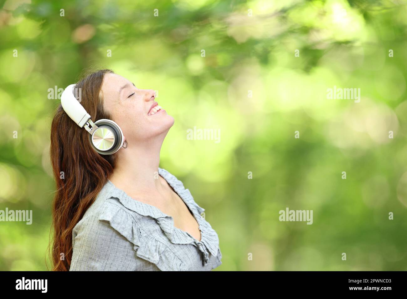 Happy woman breathing fresh air listening audio in a forest Stock Photo ...