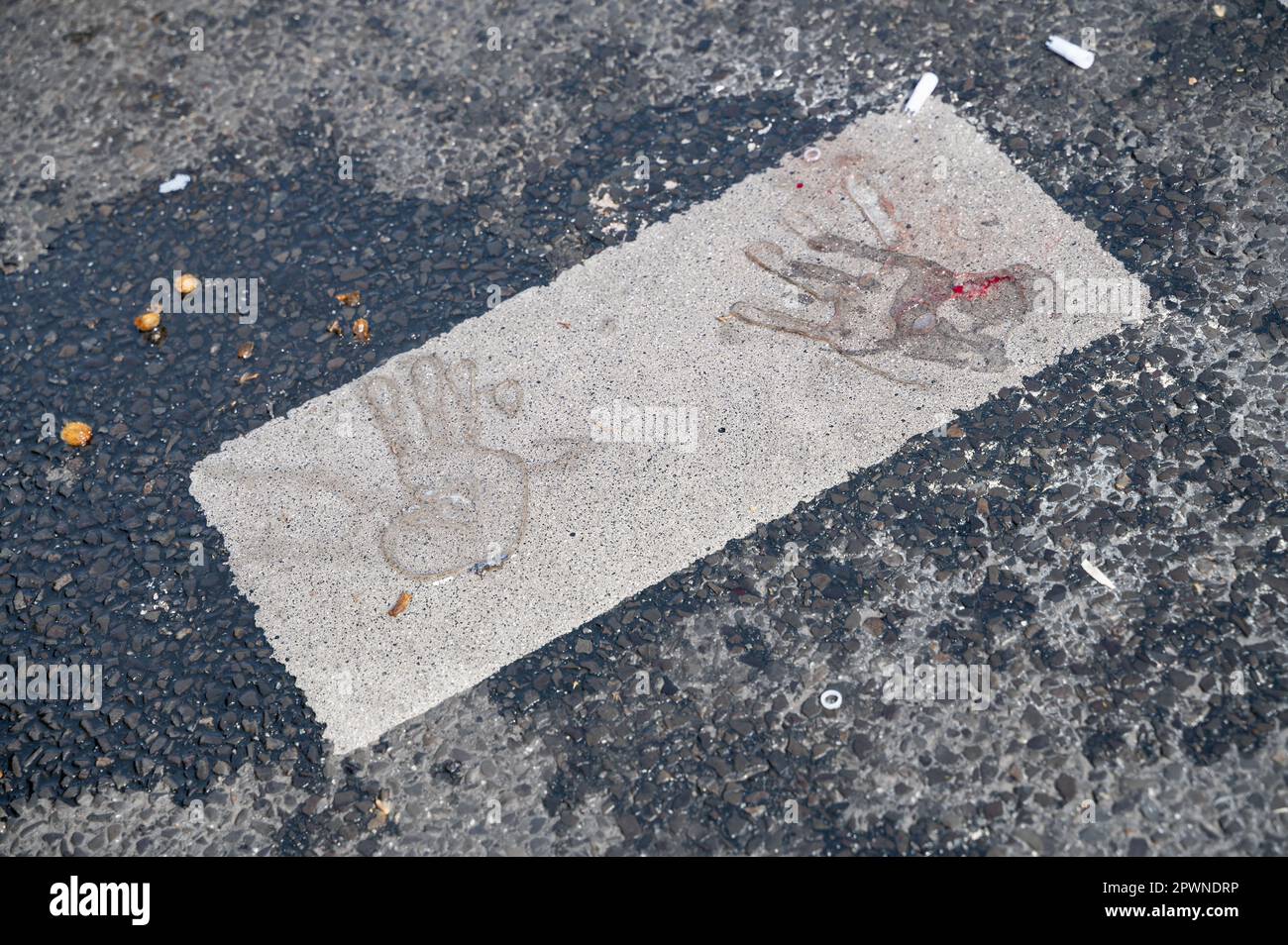 28.04.2023, Berlin, Germany, Europe - Imprints of hands, one with bloodstains, left by super glue on asphalt after Last Generation climate protest. Stock Photo