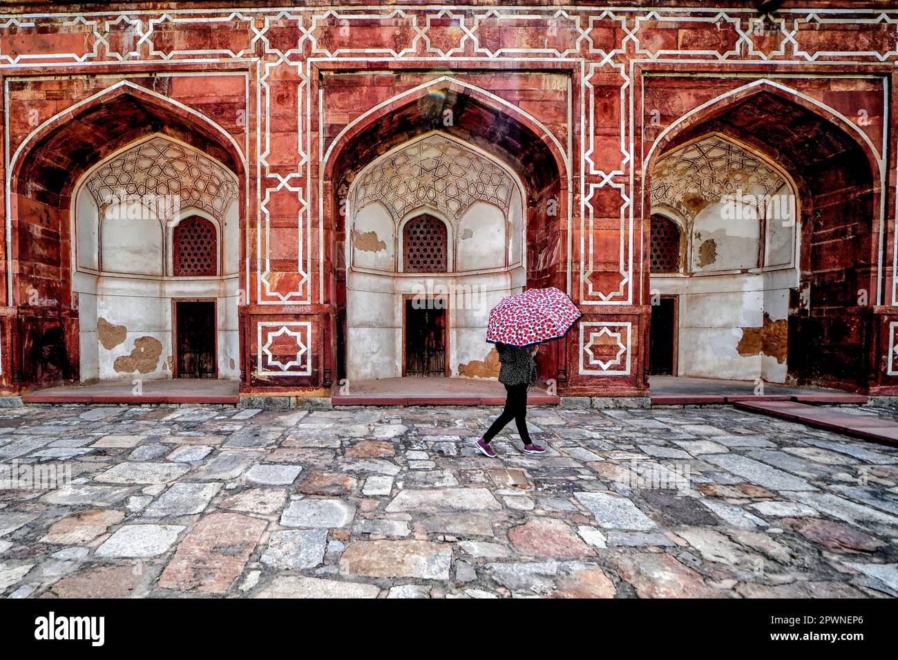 A visitor holding an umbrella walks inside the courtyard of Humayun Tomb in New Delhi. Humayun’s
