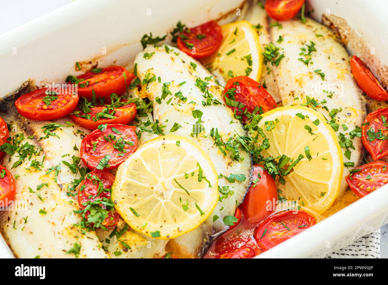 Baked cod fillet with cherry tomatoes and butter. Healthy diet recipe