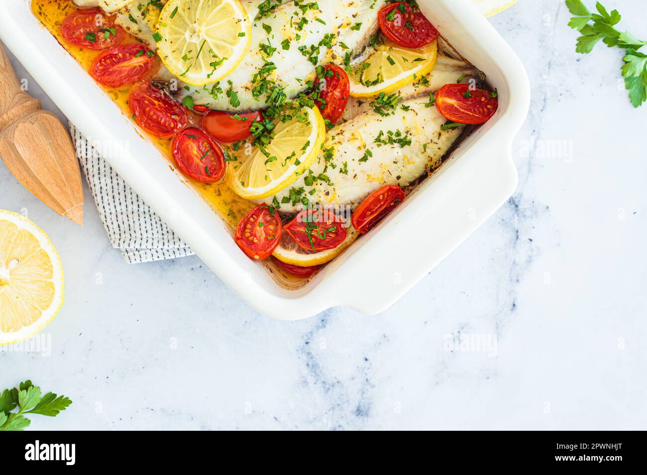 Baked cod fillet with cherry tomatoes and butter, top view. Healthy