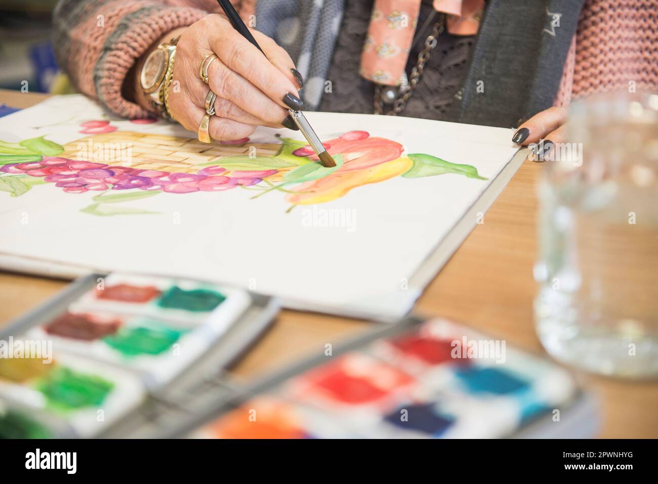 Senior woman painting fruit using water color Stock Photo