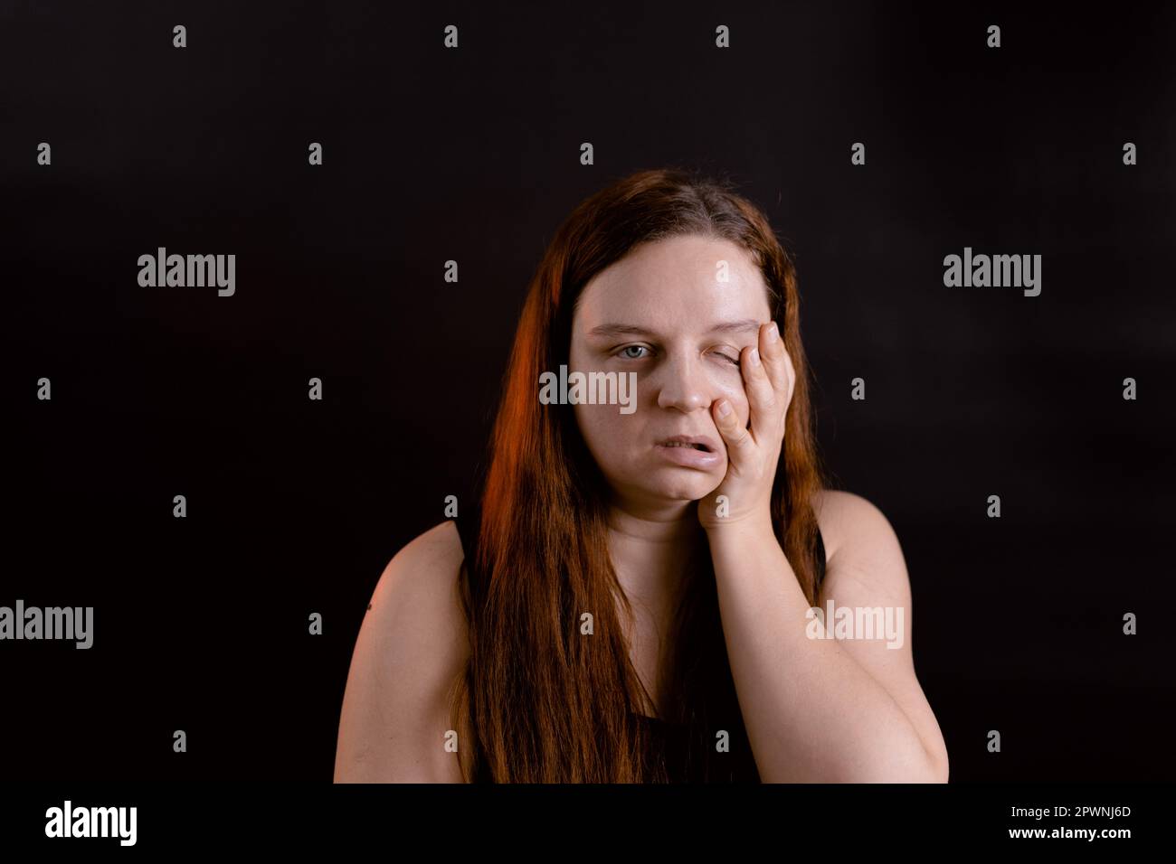 Tired young woman running hand down face. Oddish girl making faces