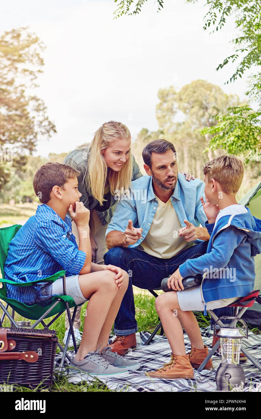 Making sure they stay safe in the forest. a family of four camping in