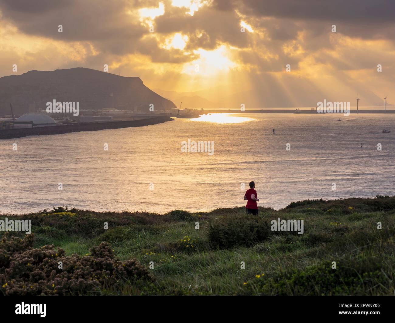 Man trail running in front of port of Bilbao Stock Photo