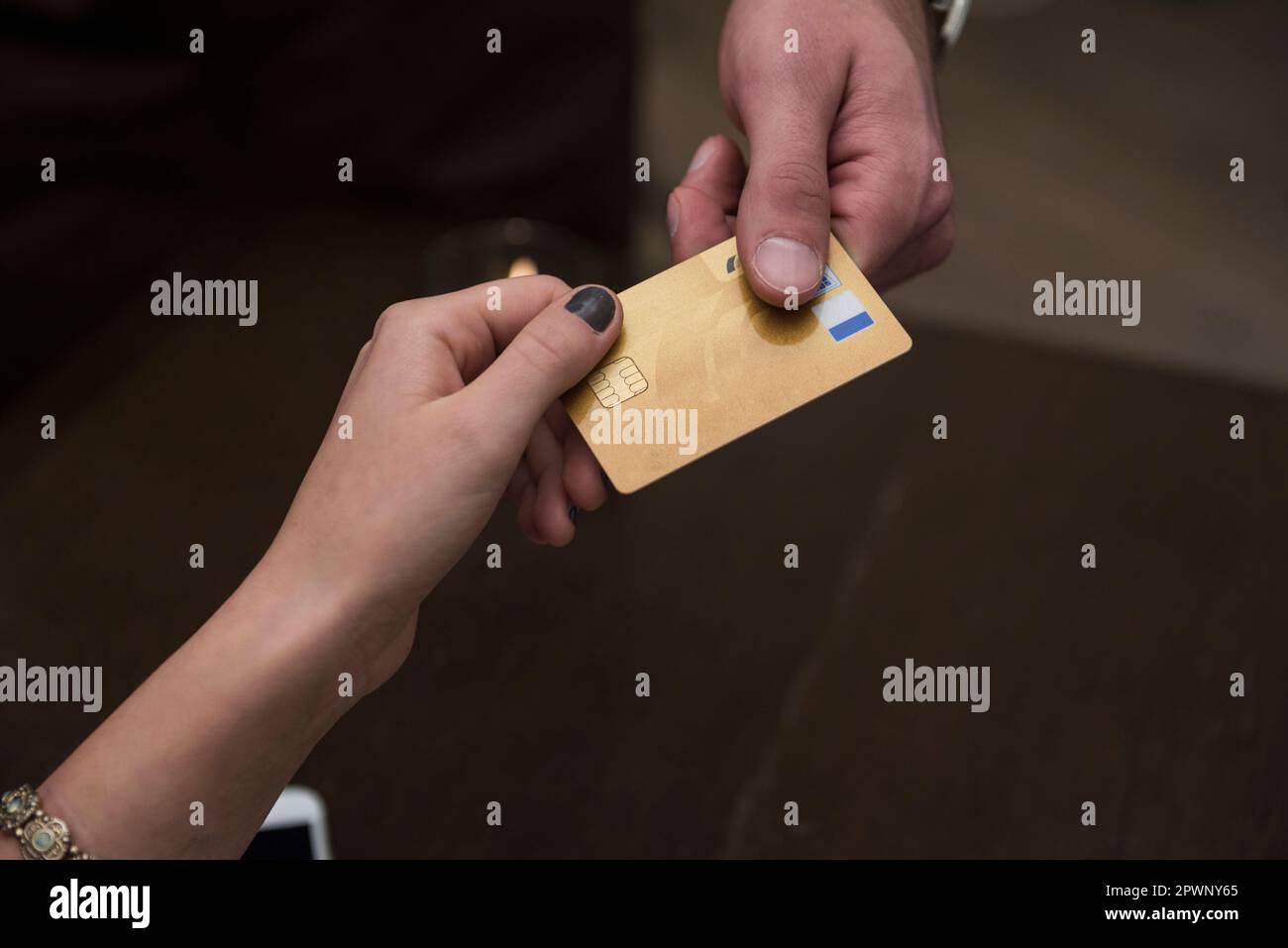 Cropped image of hands holding credit card at restaurant Stock Photo