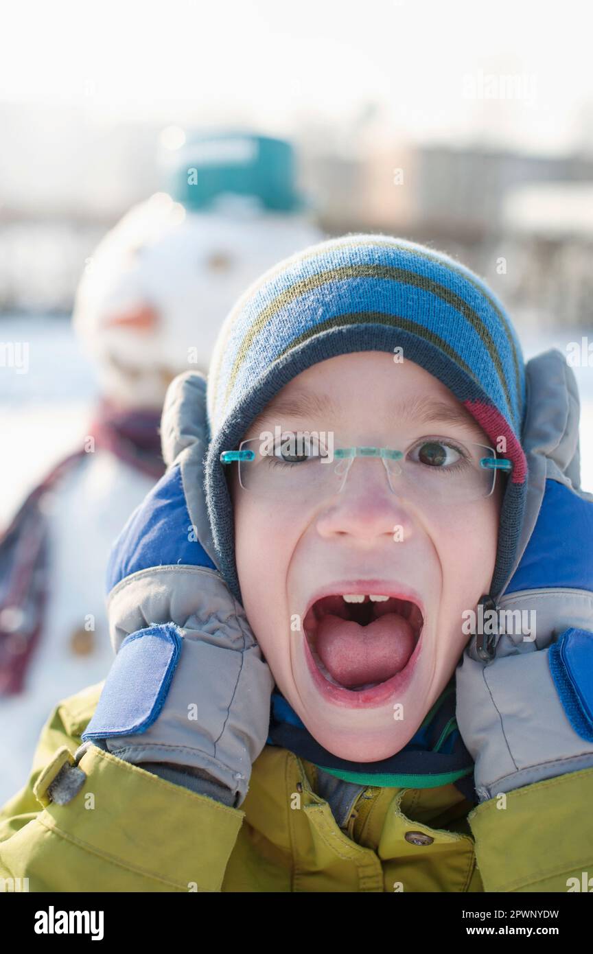 Portrait of boy covering his ears and screaming Stock Photo Alamy