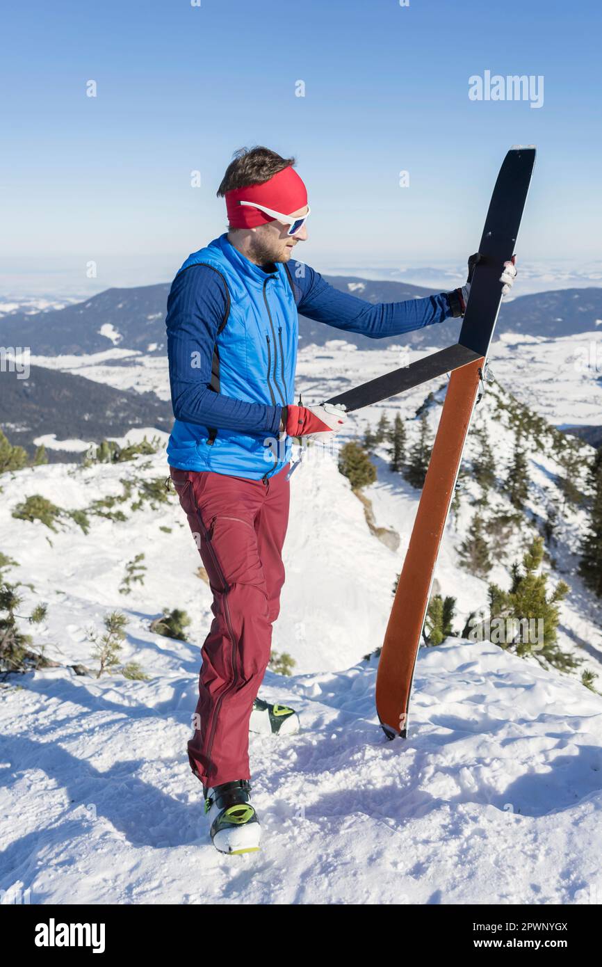 Man holding skis on mountain Stock Photo - Alamy