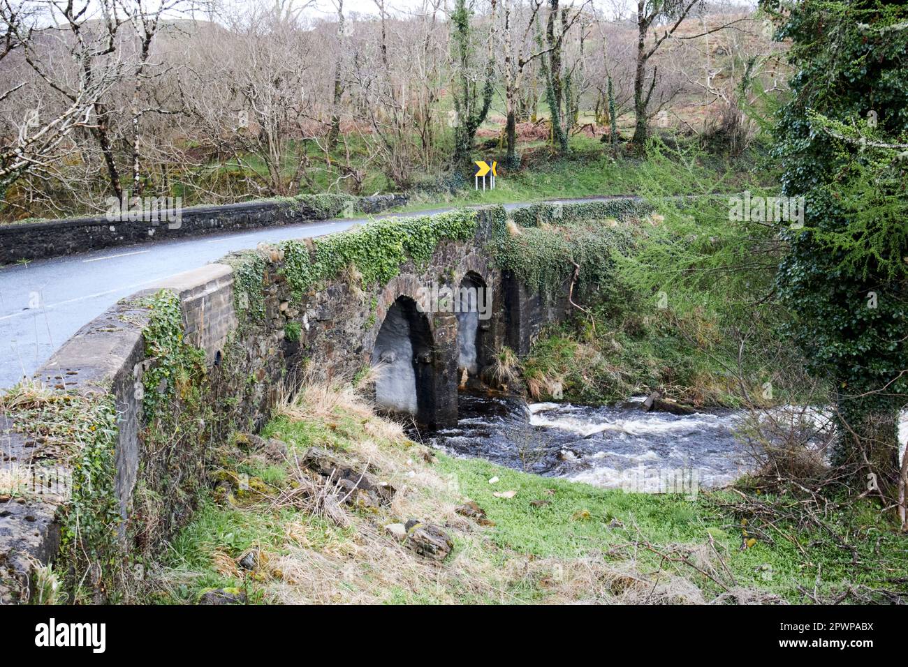 narrow bridge on the wild atlantic way with river in flood county ...