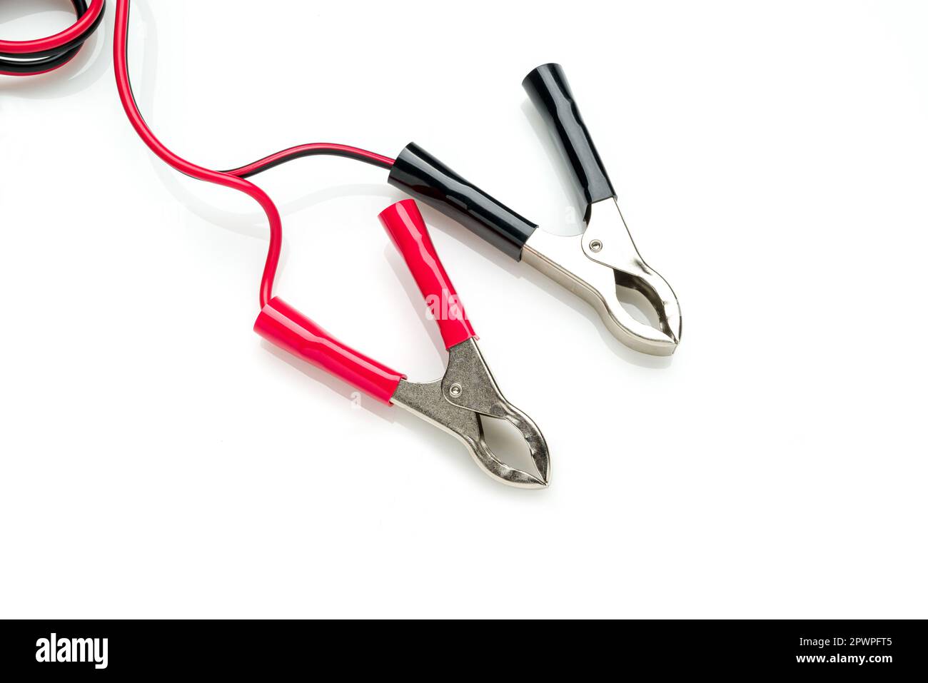 Red and black clip-on connecting and charging cable for 12 Volt battery isolated on white background Stock Photo