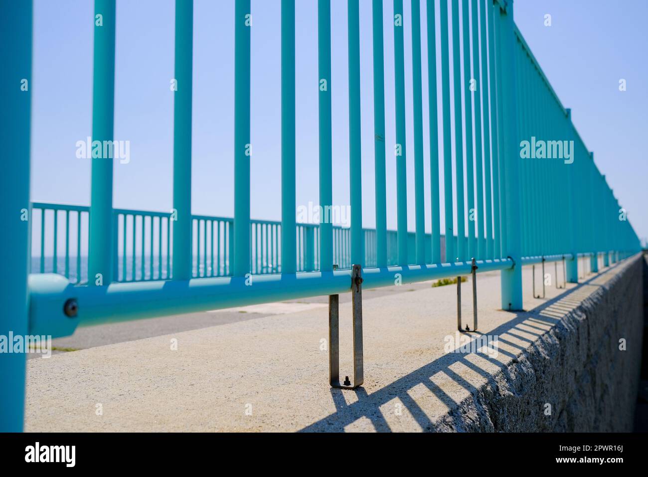 Teal-coloured metal railing at a seaside park in summer, taken at ...