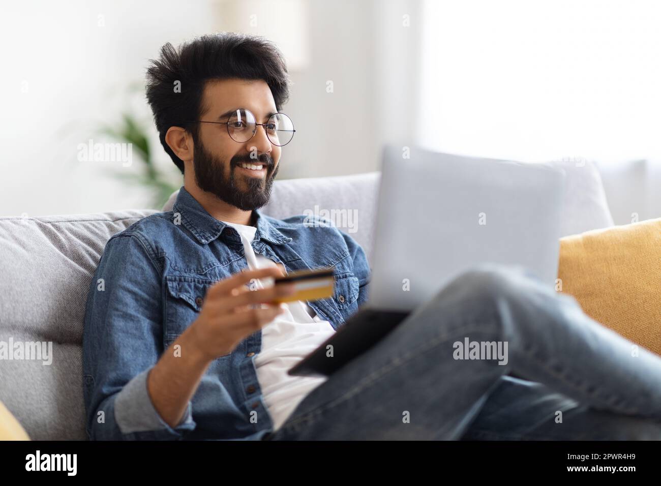 Smiling Indian Man In Eyeglasses Using Laptop And Credit Card At Home ...