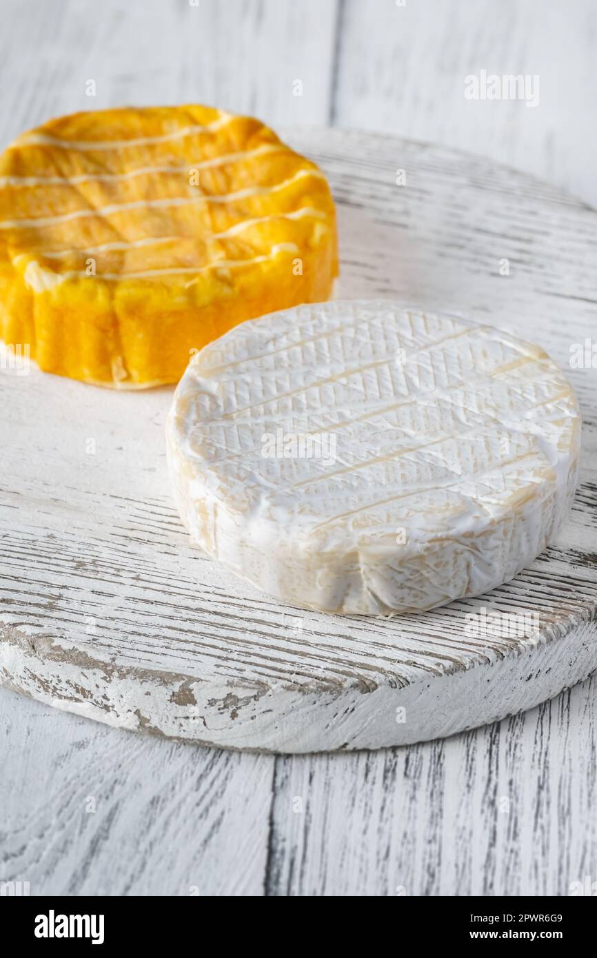 Two camembert cheese wheels on the cutting board Stock Photo Alamy