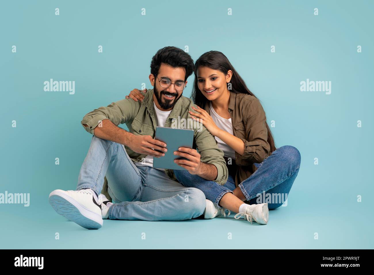 Loving young indian couple using digital tablet together Stock Photo