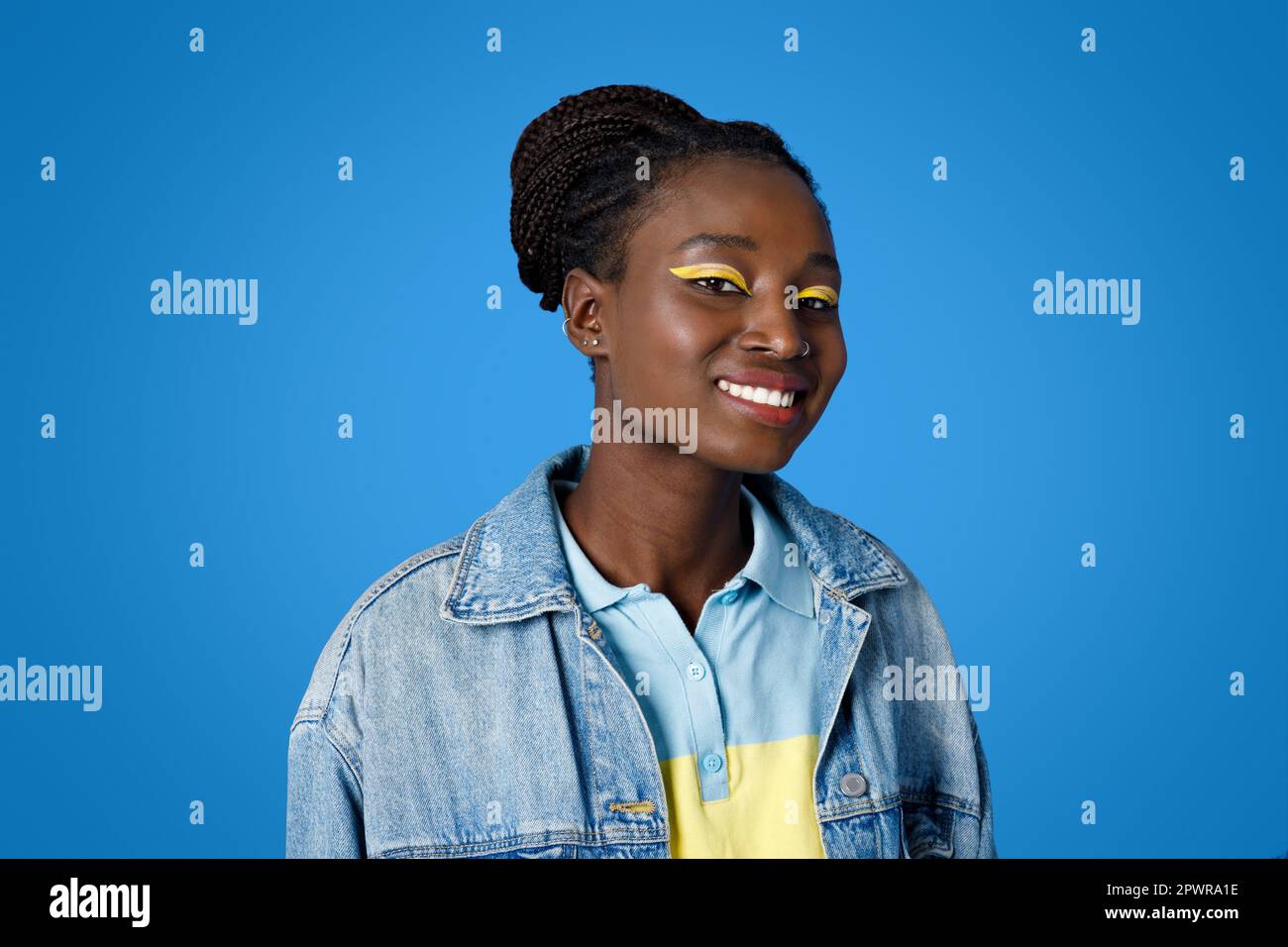 Portrait of cute young black woman smiling on blue Stock Photo - Alamy