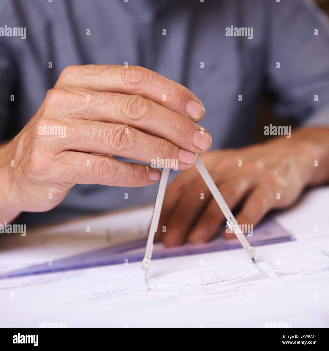 Geometry matters. Closeup shot of a draftsman using a triangle and compass to draw up building plans. Stock Photo