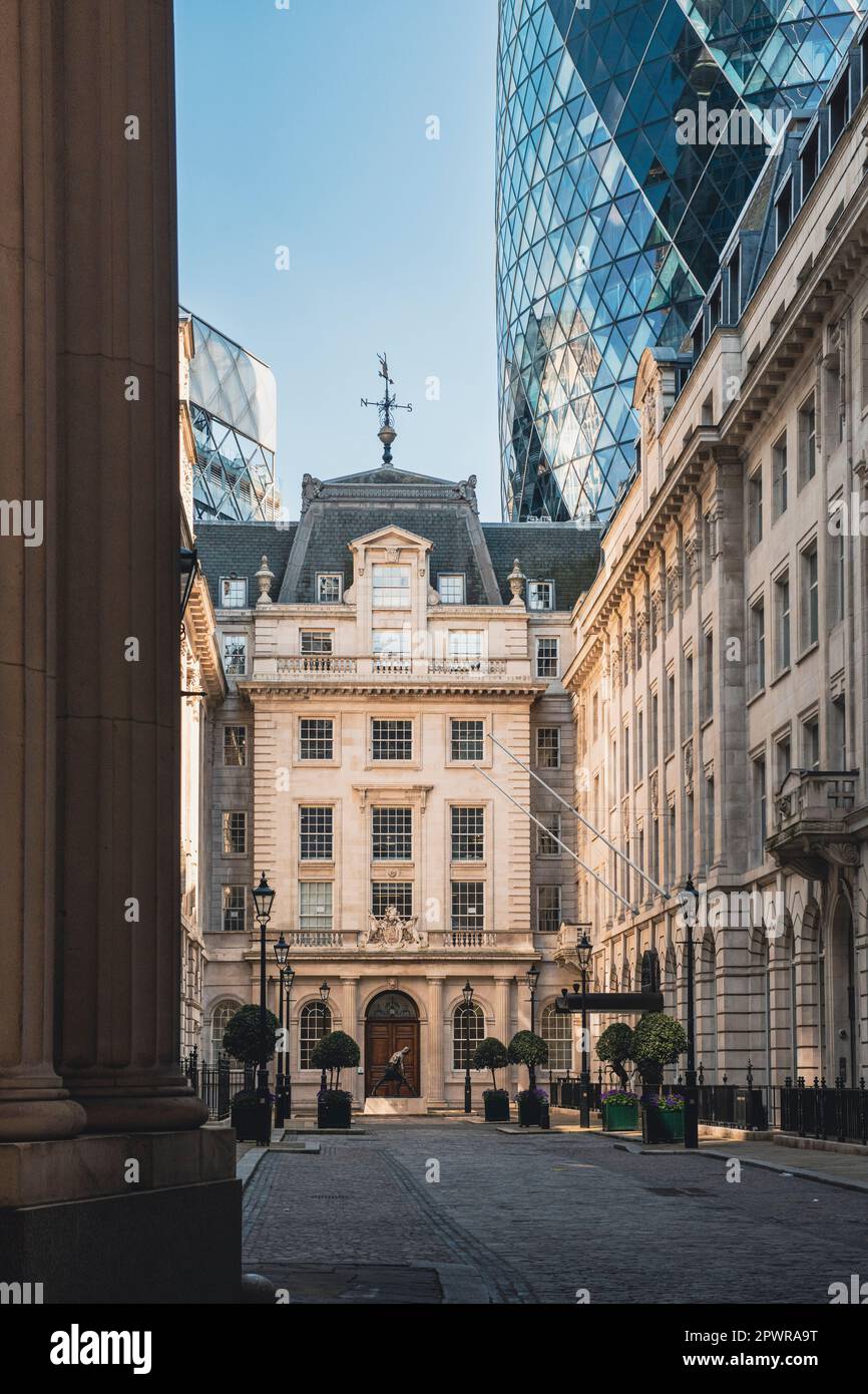 The entrance to the Leatherseller company with the Gherkin in the background seen from the street behind a closed gate. Stock Photo