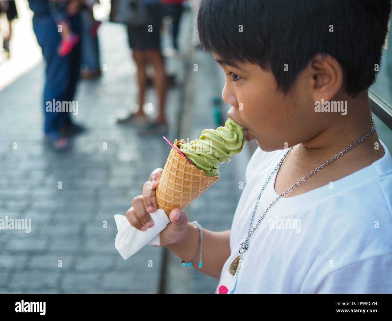 A Boy Wearing A White Shirt Is Eating Ice Cream Stock Photo