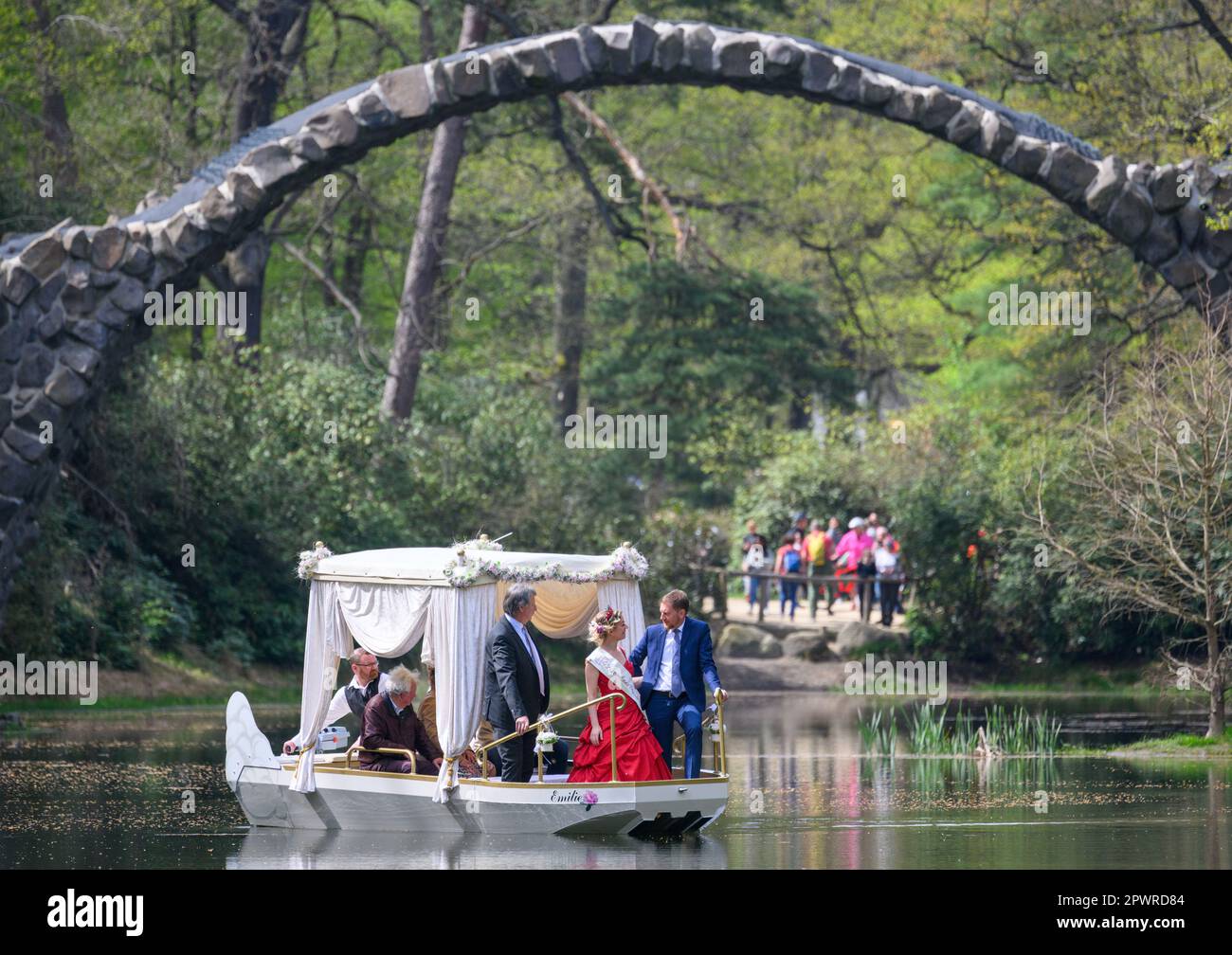 01 May 2023, Saxony, Gablenz: Michael Kretschmer (CDU, r.), Prime Minister of Saxony, the Kromlau Blossom King Stefanie Engler (M) and Dietmar Noack (l.) Mayor of Gablenz drive the newly christened wedding barge 'Emilie' under the Rakotz Bridge in the Rhododendron Park Kromlau. The gondola can soon be rented by wedding couples, but also by other visitors. Photo: Robert Michael/dpa Stock Photo