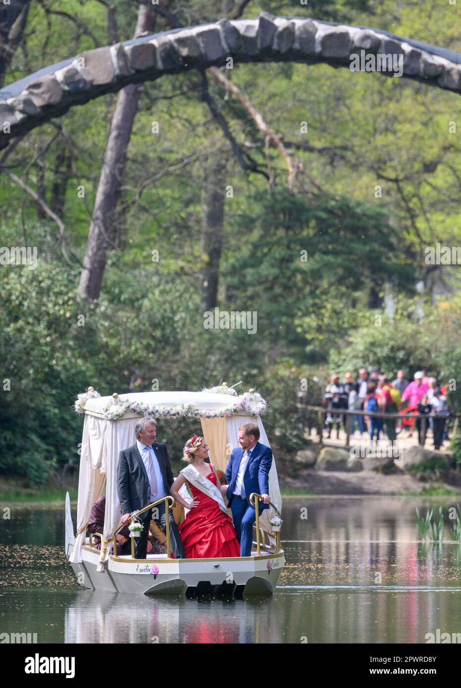 Gablenz, Germany. 01st May, 2023. Michael Kretschmer (CDU, r.), Prime Minister of Saxony, the Kromlau Blossom King Stefanie Engler (M) and Dietmar Noack (l.) Mayor of Gablenz drive the newly christened wedding barge 'Emilie' under the Rakotz Bridge in the Rhododendron Park Kromlau. The gondola can soon be rented by wedding couples, but also by other visitors. Credit: Robert Michael/dpa/Alamy Live News Stock Photo