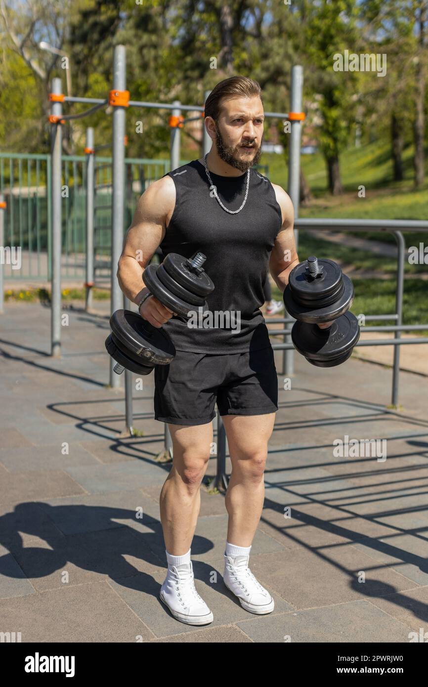 Athletic lebanese man in sportswear doing arm shoulders weight lifting